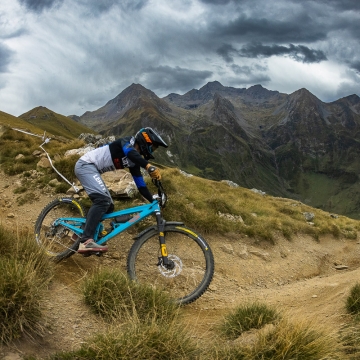 Scenic photo of Orange Team rider with mountains in background
