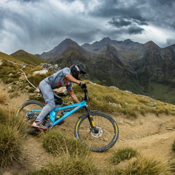 Scenic photo of Orange Team rider with mountains in background